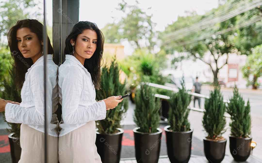 Linda garota latina usando seu celular.