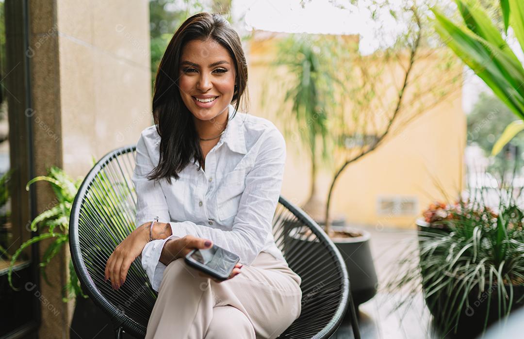 Linda garota latina usando seu celular.