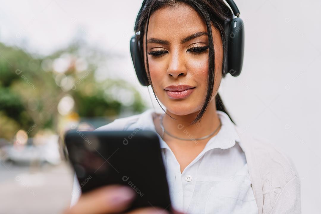 Linda garota latina usando seu celular.