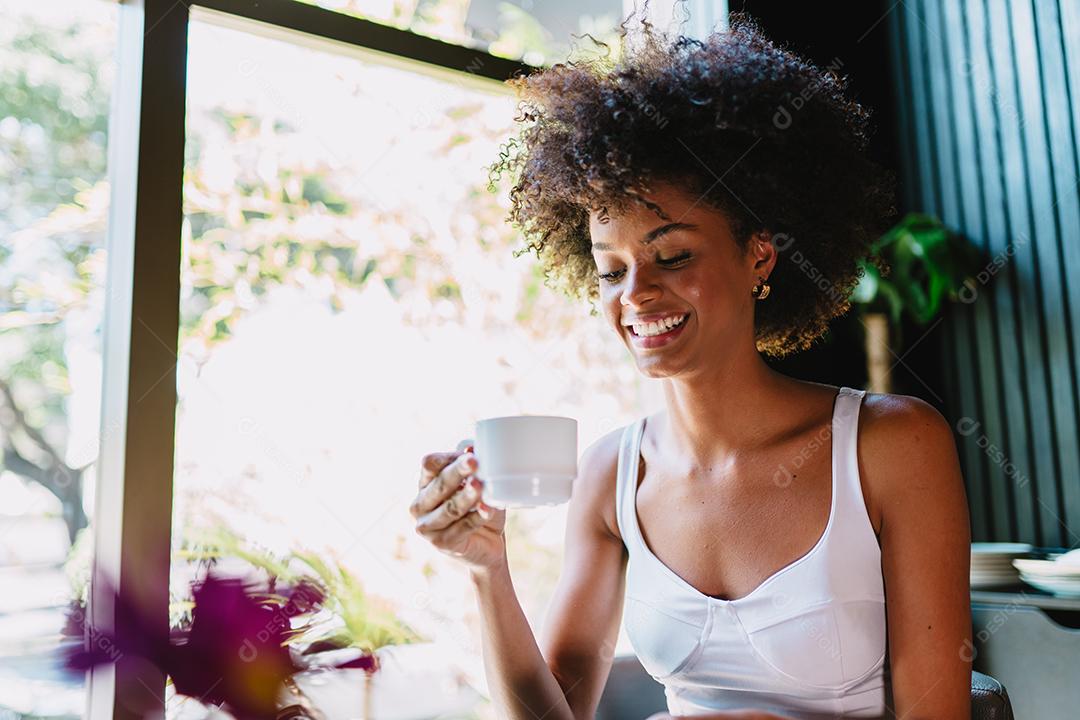 Latin woman in a cafe drinking coffee.