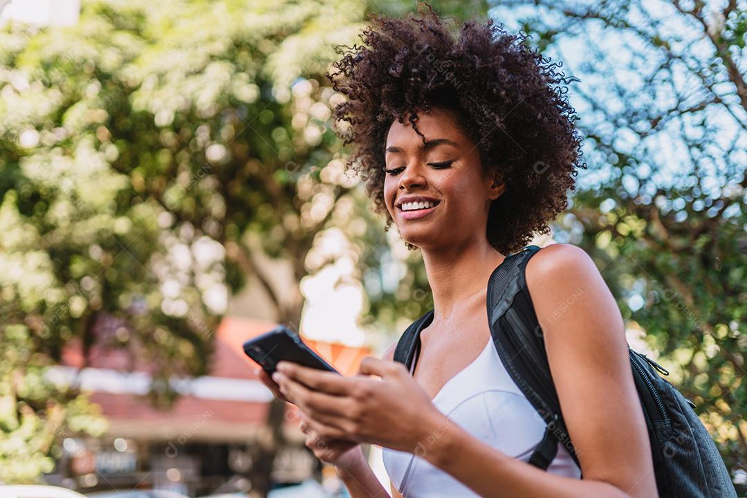 Linda garota latina usando seu celular.