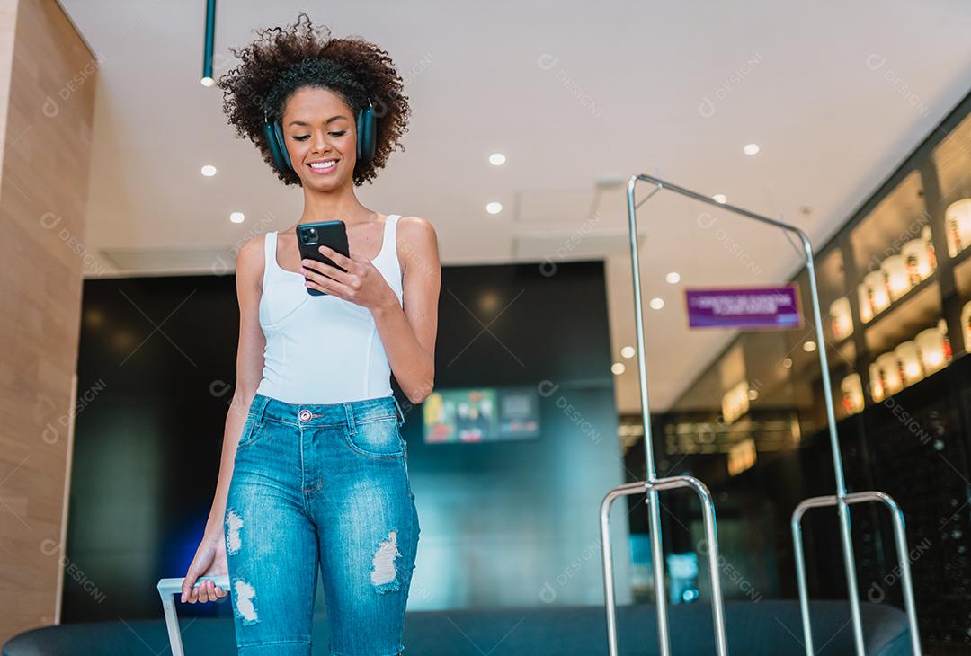 Mulher com mala no lobby. Check-in no hotel.