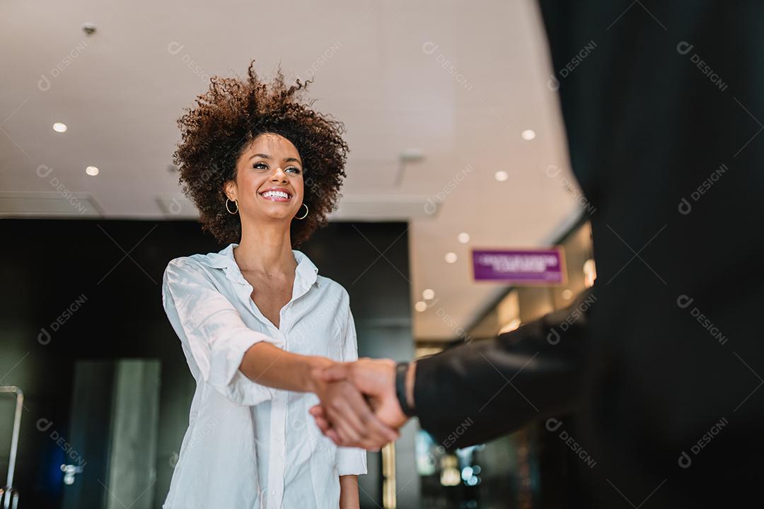 Empresário e mulher apertam as mãos como olá no escritório