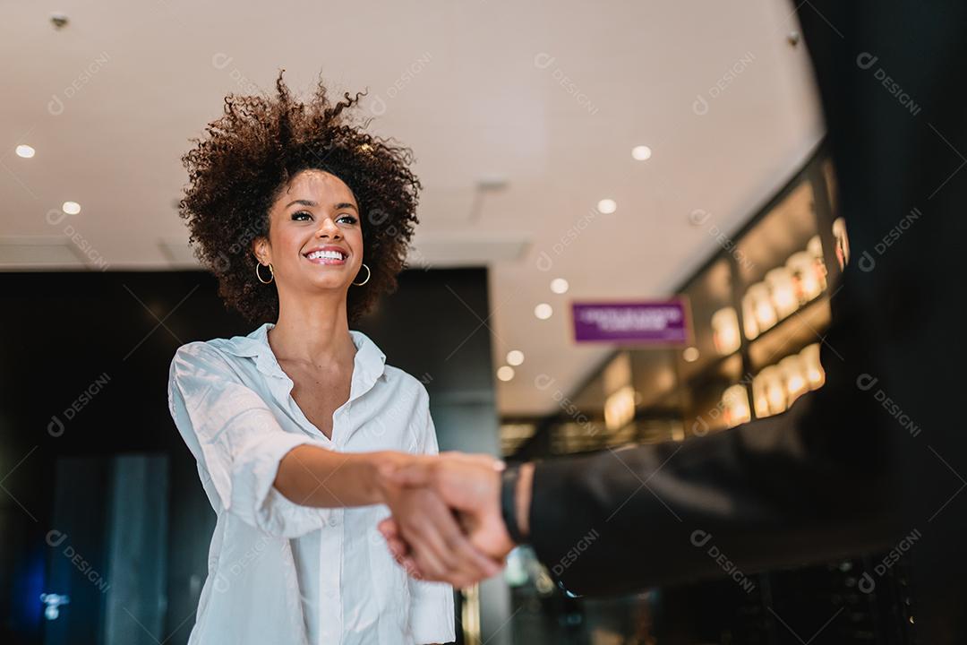 Empresário e mulher apertam as mãos como olá no escritório