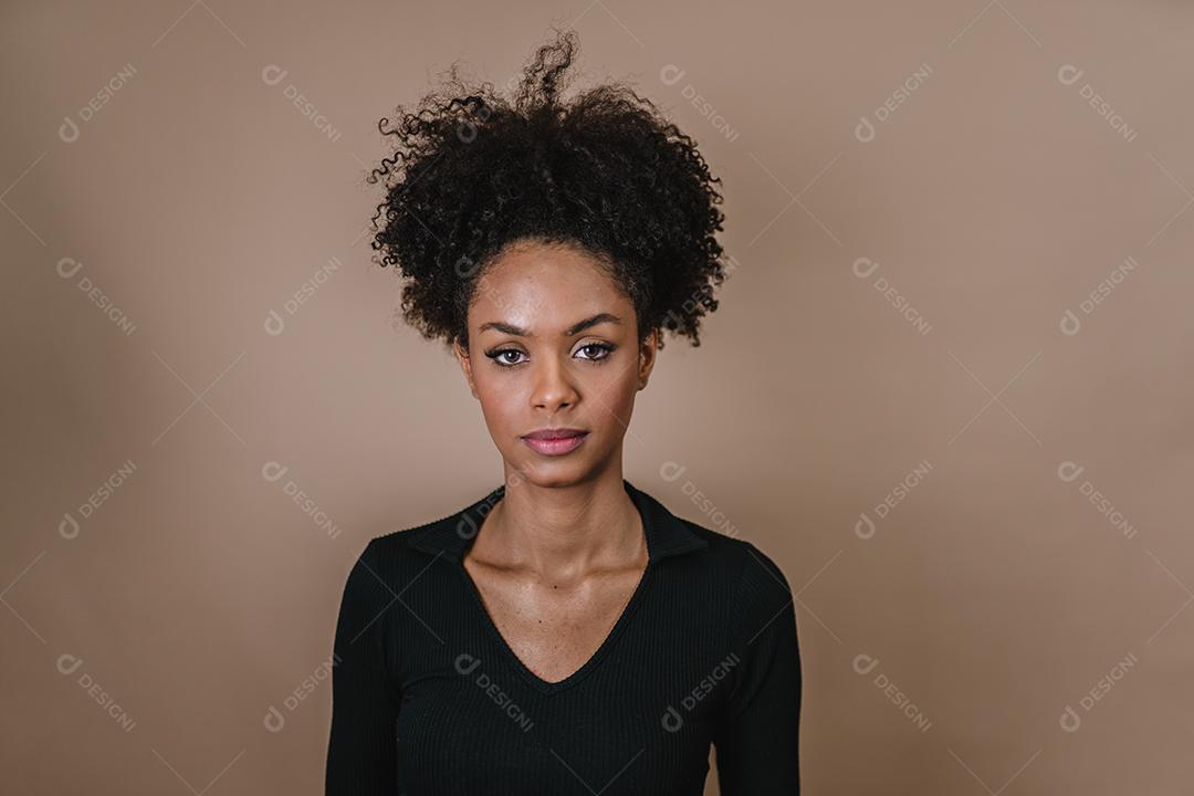 Jovem afro latina sorridente. Alegria, positivo e amor. Lindo cabelo estilo africano. Fundo pastel de estúdio.