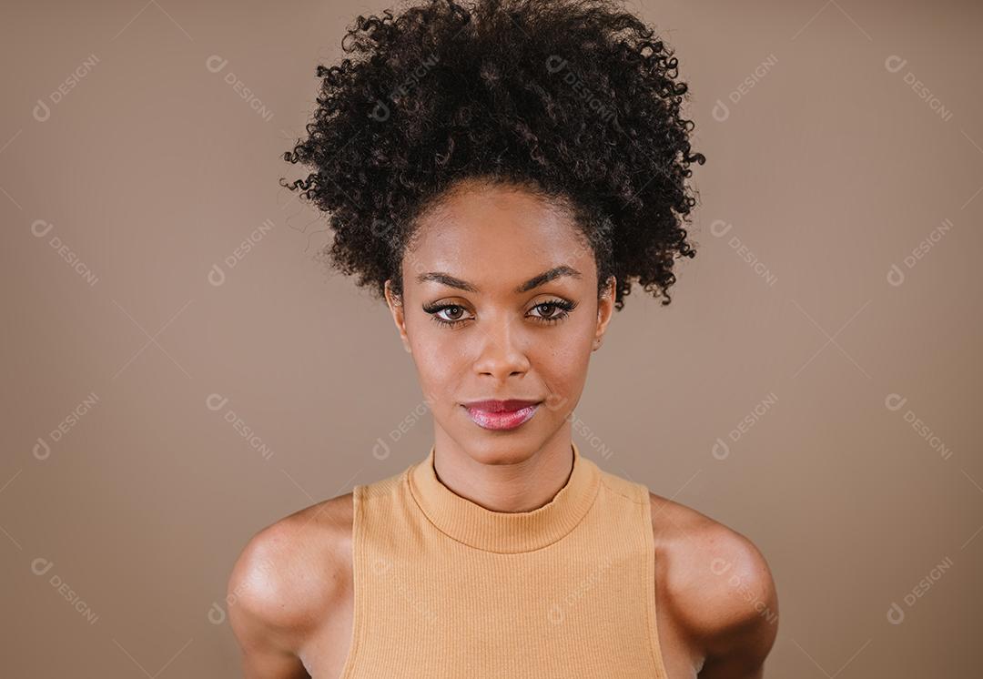 Jovem afro latina sorridente. Alegria, positivo e amor. Lindo cabelo estilo africano. Fundo pastel de estúdio.