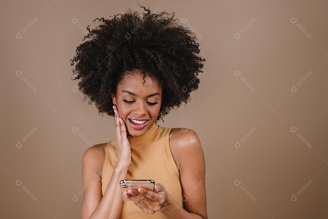 Muito jovem latina usando smartphone em pé sobre fundo pastel isolado, sentindo-se feliz.
