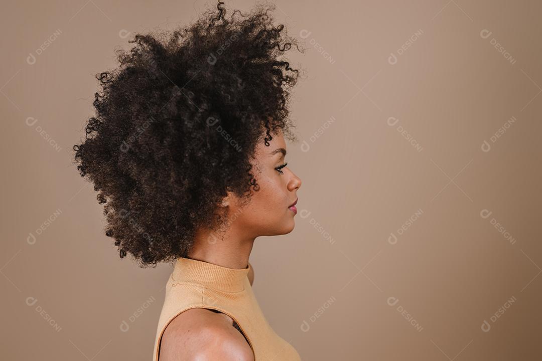 Lado uma jovem mulher afro latina sorridente. Alegria, positivo e amor. Lindo cabelo estilo africano