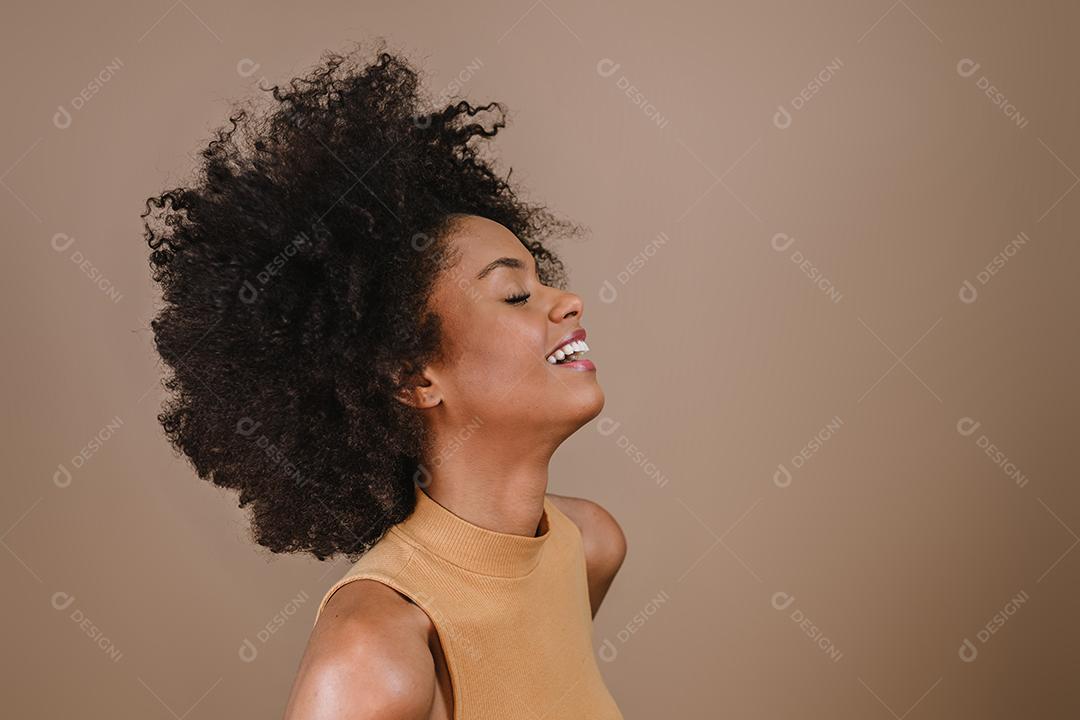 Lado uma jovem mulher afro latina sorridente. Alegria, positivo e amor. Lindo cabelo estilo africano