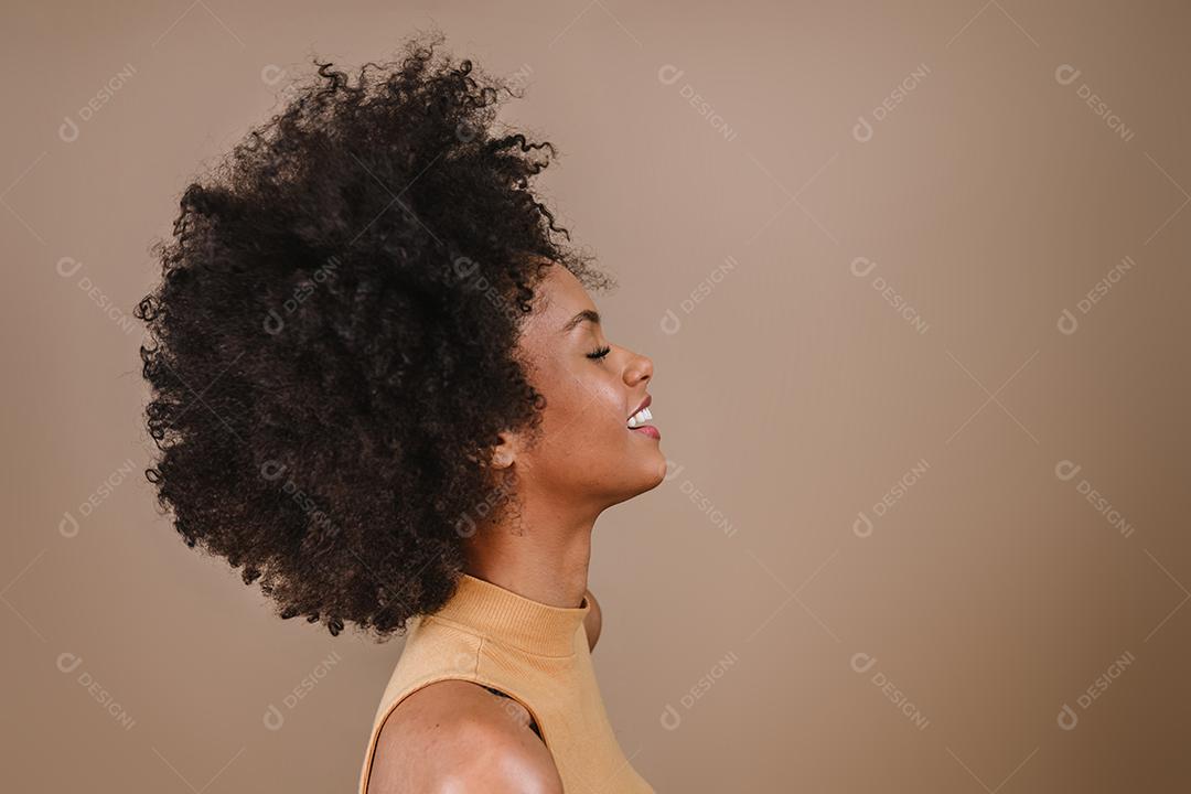 Lado uma jovem mulher afro latina sorridente. Alegria, positivo e amor. Lindo cabelo estilo africano