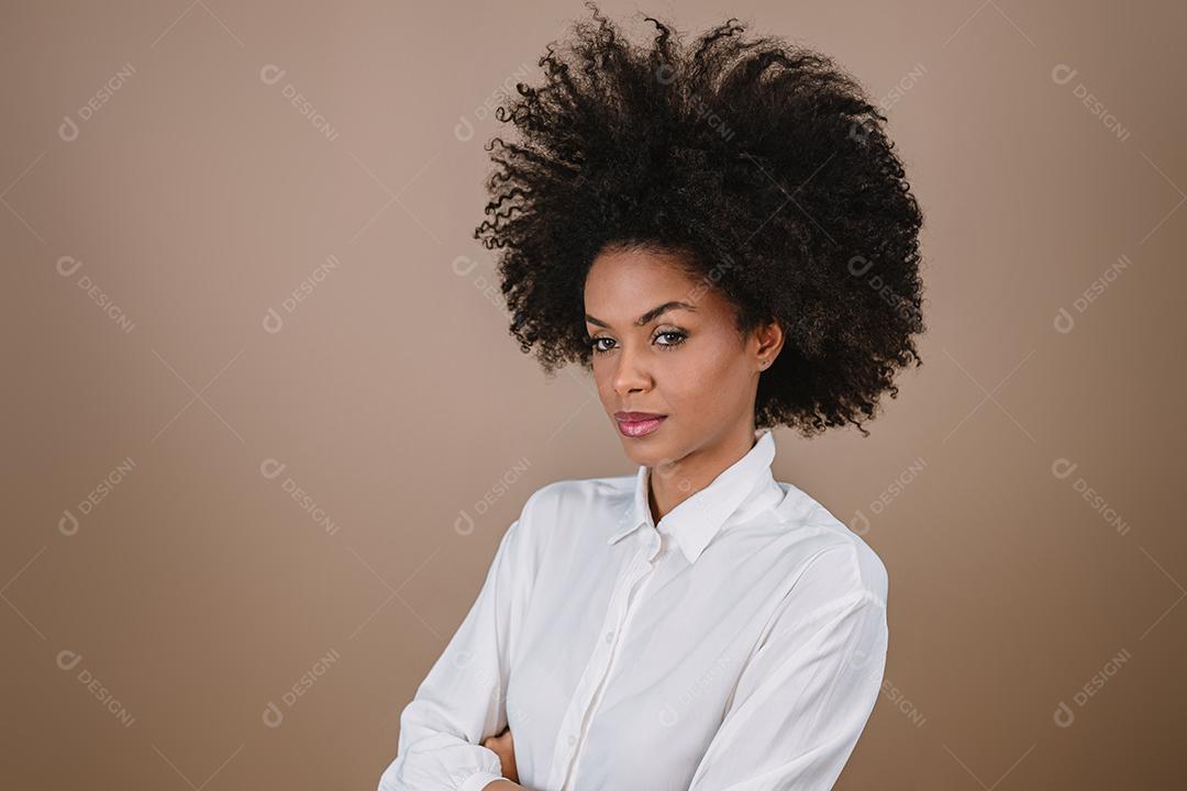 Jovem sorridente Latina afro cruzando os braços. Alegria, positivo e amor. Lindo cabelo estilo africano