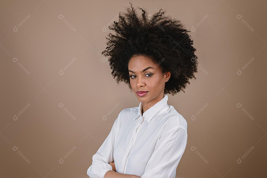 Jovem sorridente Latina afro cruzando os braços. Alegria, positivo e amor. Lindo cabelo estilo africano