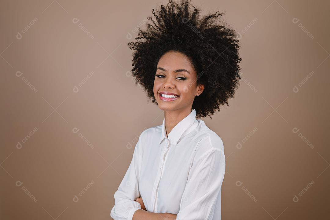 Jovem sorridente Latina afro cruzando os braços. Alegria, positivo e amor. Lindo cabelo estilo africano