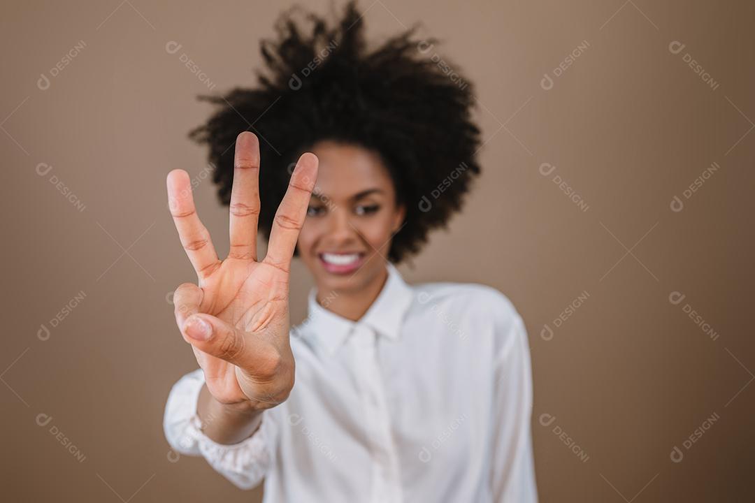 Mulher latina sorridente fazendo três vezes a contagem regressiva gesto de sinal com os dedos da mão no fundo pastel.