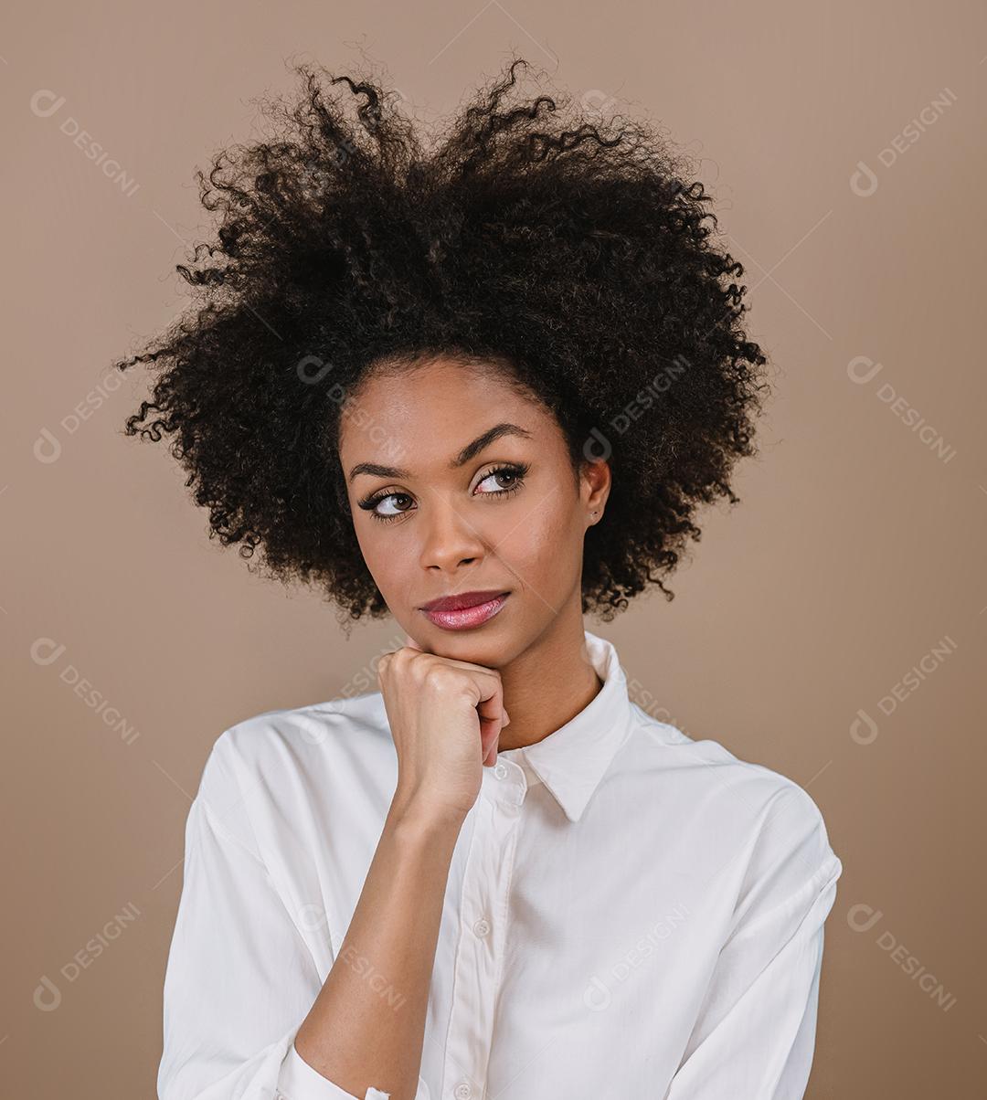 Jovem mulher afro latina pensando. Alegria, positivo e amor. Lindo cabelo estilo africano. Fundo pastel de estúdio.