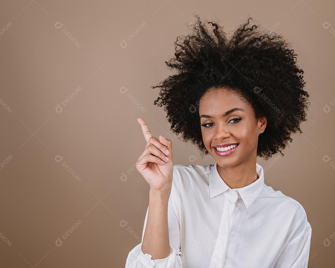 Uma jovem latina aponta para os lados. Conceito de propaganda e apresentação. Fundo pastel.