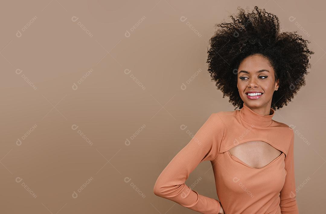 Mulher latina de beleza com penteado afro. mulher brasileira. Segurando a embalagem de xampu em branco
