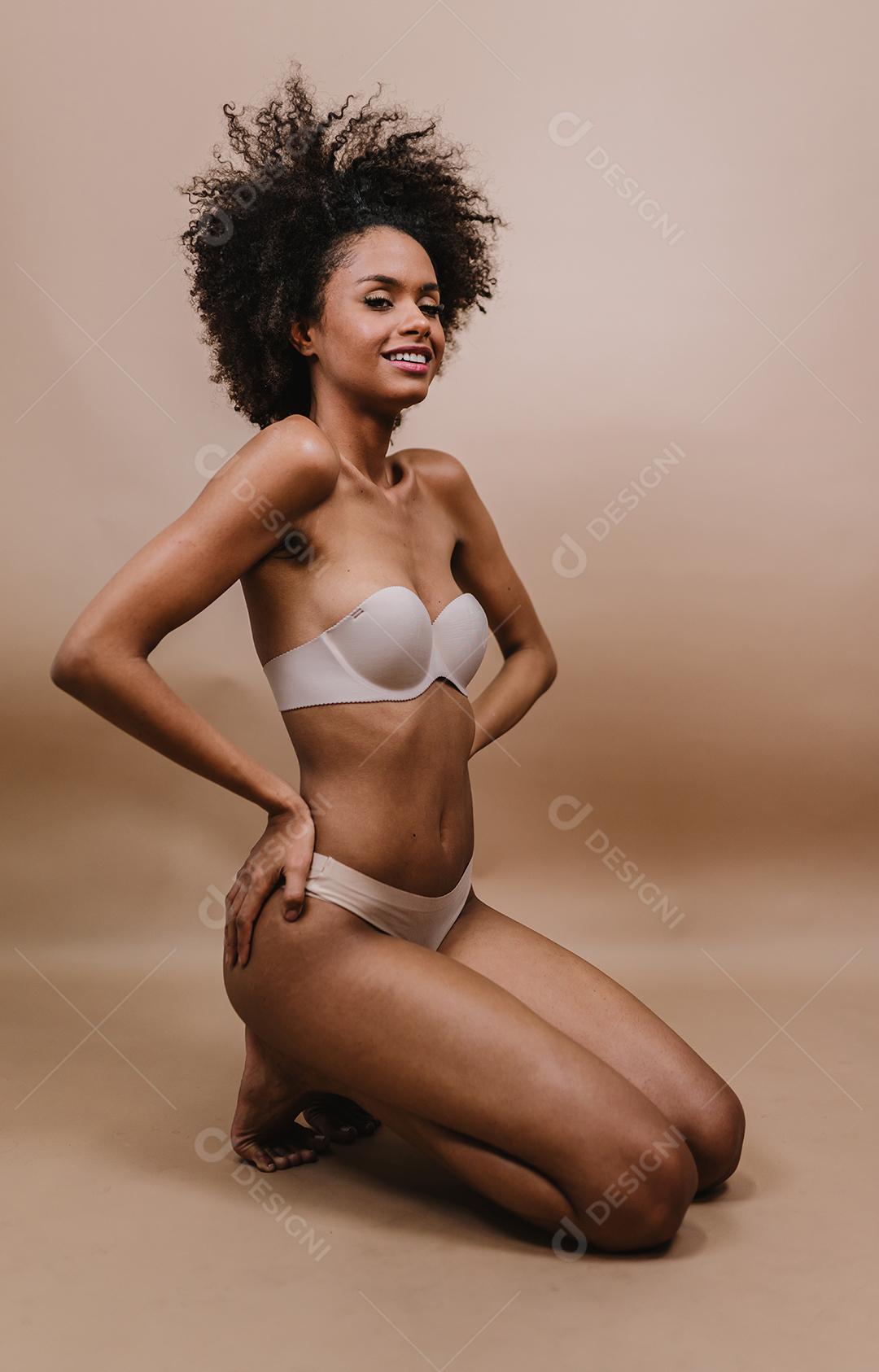 Lado uma jovem mulher afro latina sorridente. Alegria, positivo e amor. Lindo cabelo estilo africano. Fundo pastel de estúdio.