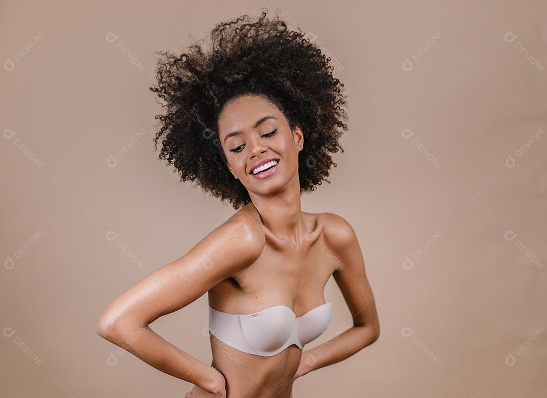 Jovem afro latina sorridente. Alegria, positivo e amor. Lindo cabelo estilo africano. Fundo pastel de estúdio.