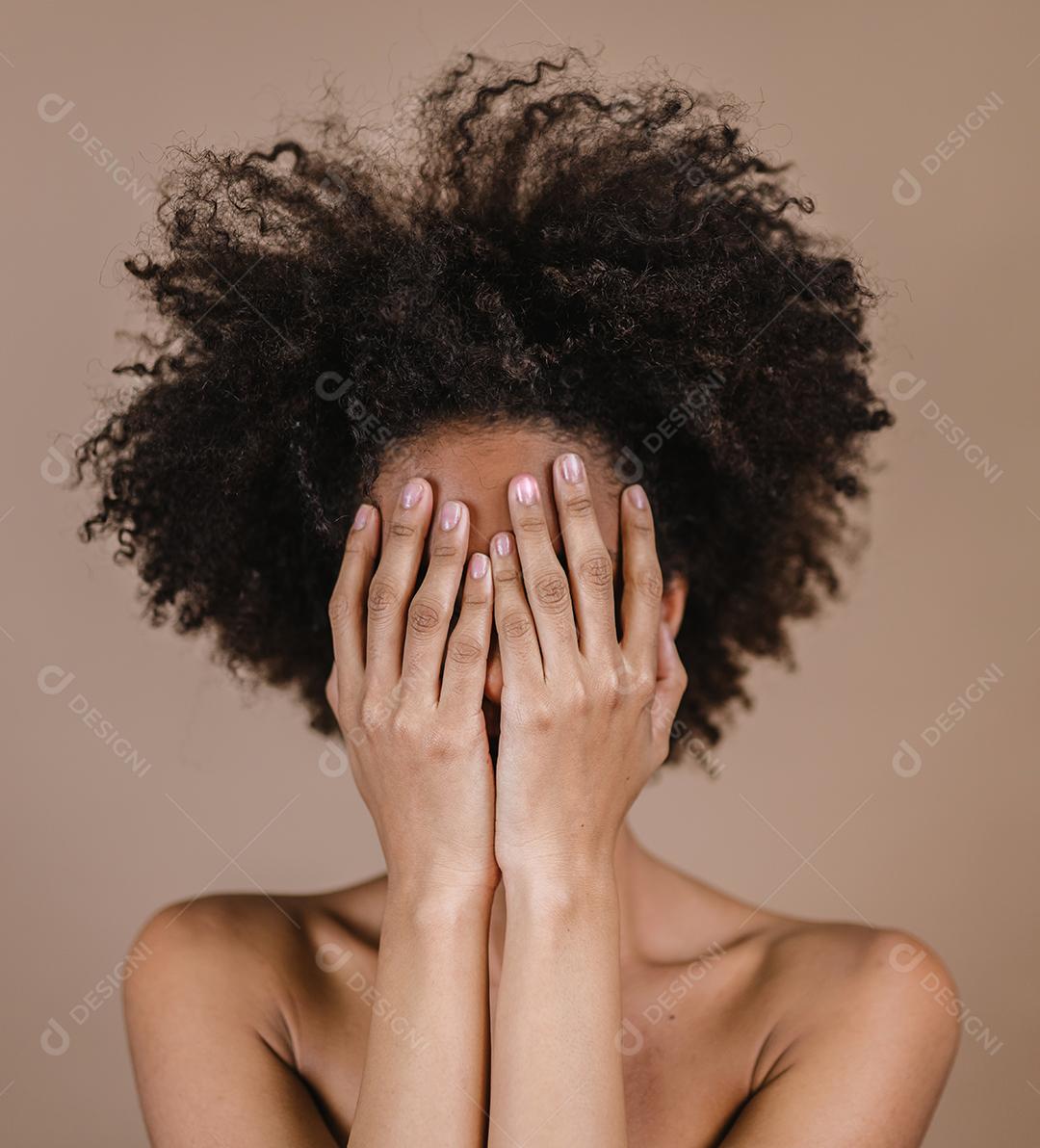 O retrato emocional de uma triste garota latina cobre o rosto com a mão dentro de casa.