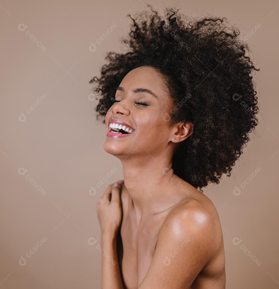 Jovem afro latina sorridente. Alegria, positivo e amor. Lindo cabelo estilo africano. Fundo pastel de estúdio.