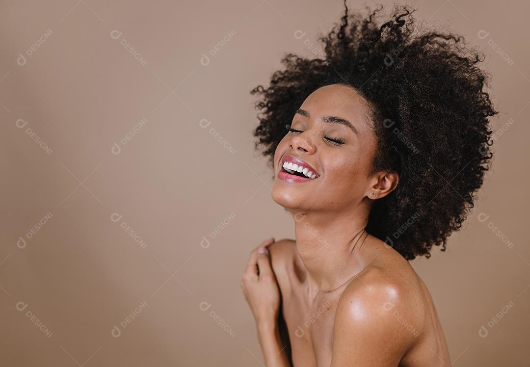 Jovem afro latina sorridente. Alegria, positivo e amor. Lindo cabelo estilo africano. Fundo pastel de estúdio.