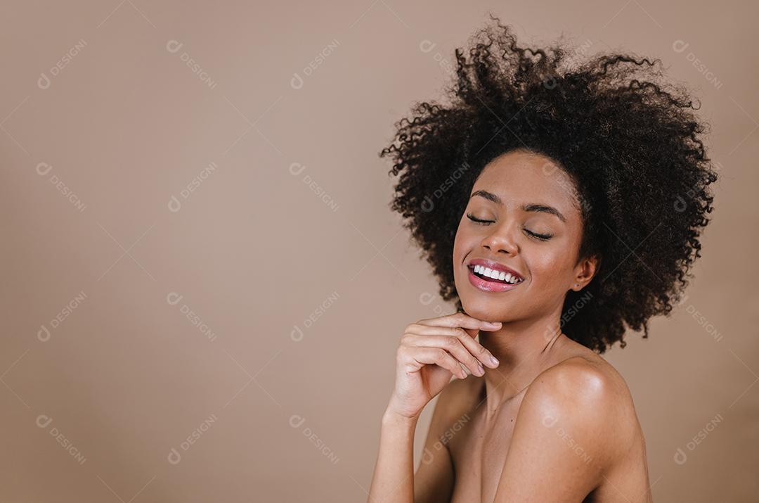 Jovem afro latina sorridente. Alegria, positivo e amor. Lindo cabelo estilo africano. Fundo pastel de estúdio.