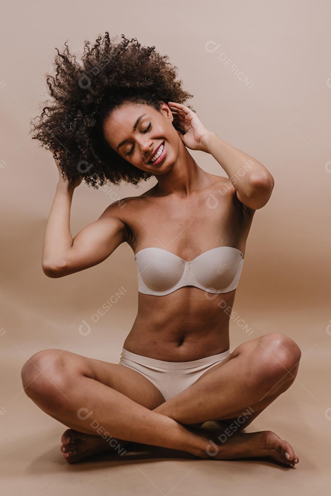 Jovem afro latina sorridente. Alegria, positivo e amor. Lindo cabelo estilo africano. Fundo pastel de estúdio.