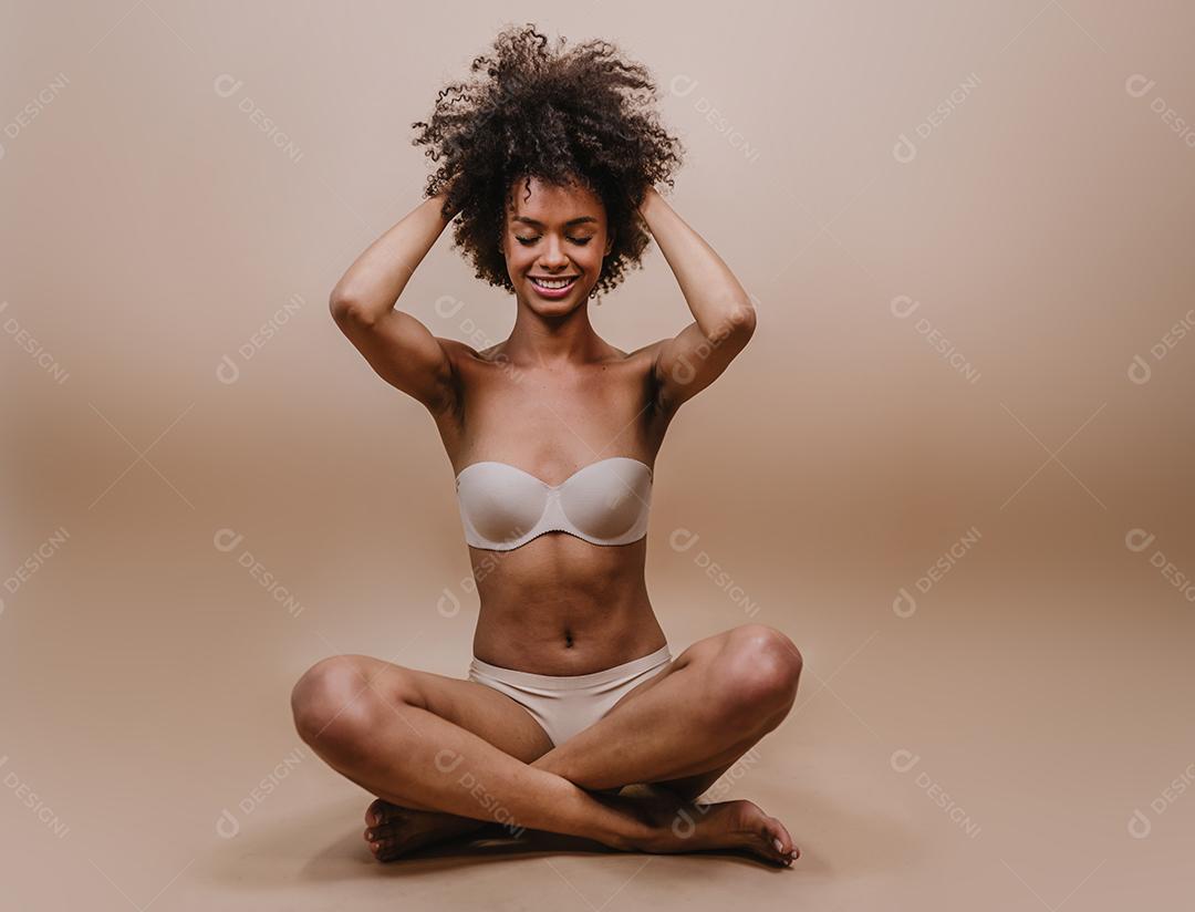 Jovem afro latina sorridente. Alegria, positivo e amor. Lindo cabelo estilo africano. Fundo pastel de estúdio.