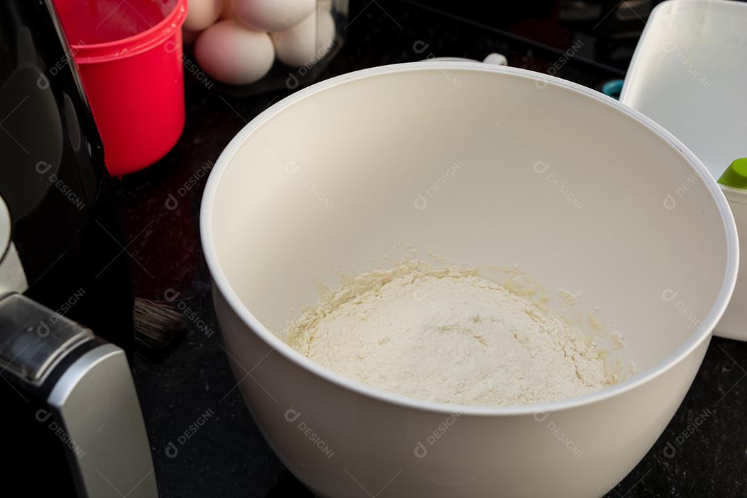 farinha dentro de uma batedeira em uma superfície de mármore preto. preparando o lanche da família