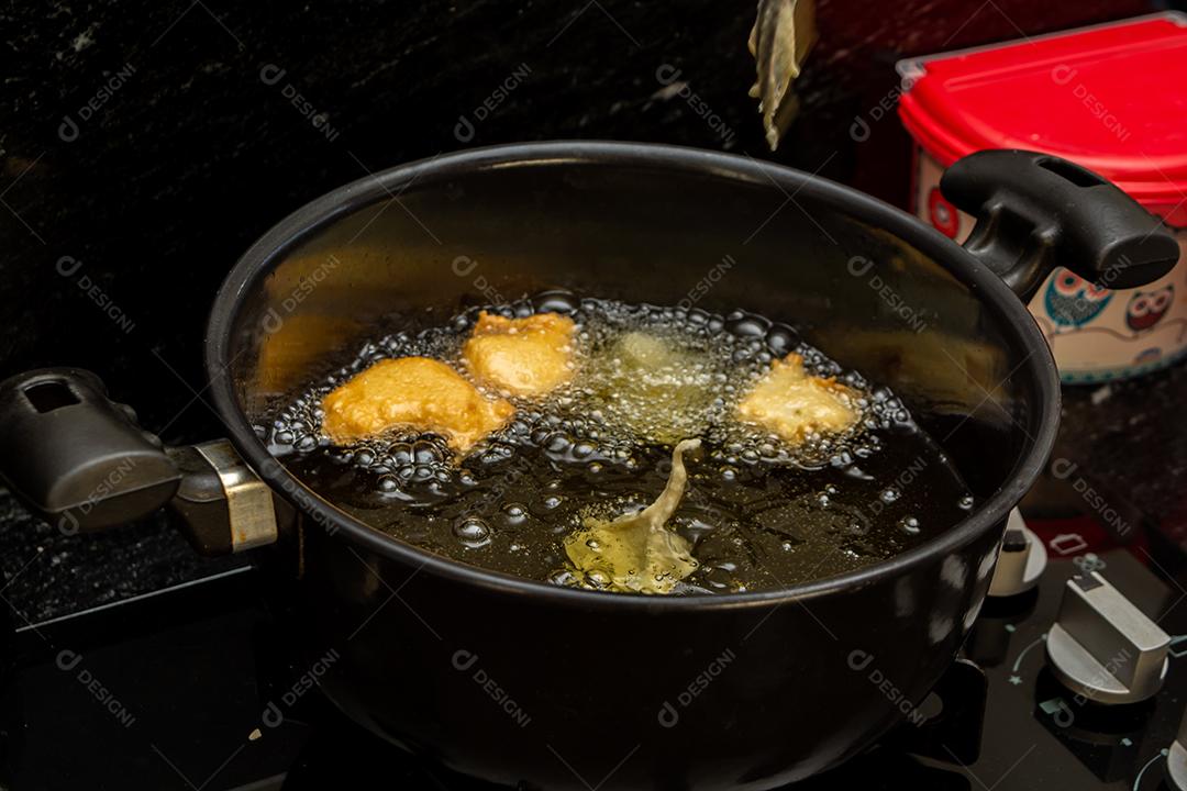 fritar a massa no óleo, para uma receita típica brasileira chamada bolinho de chuva