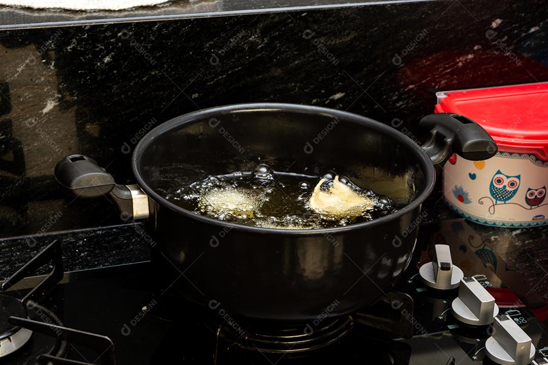 fritar a massa no óleo, para uma receita típica brasileira chamada bolinho de chuva