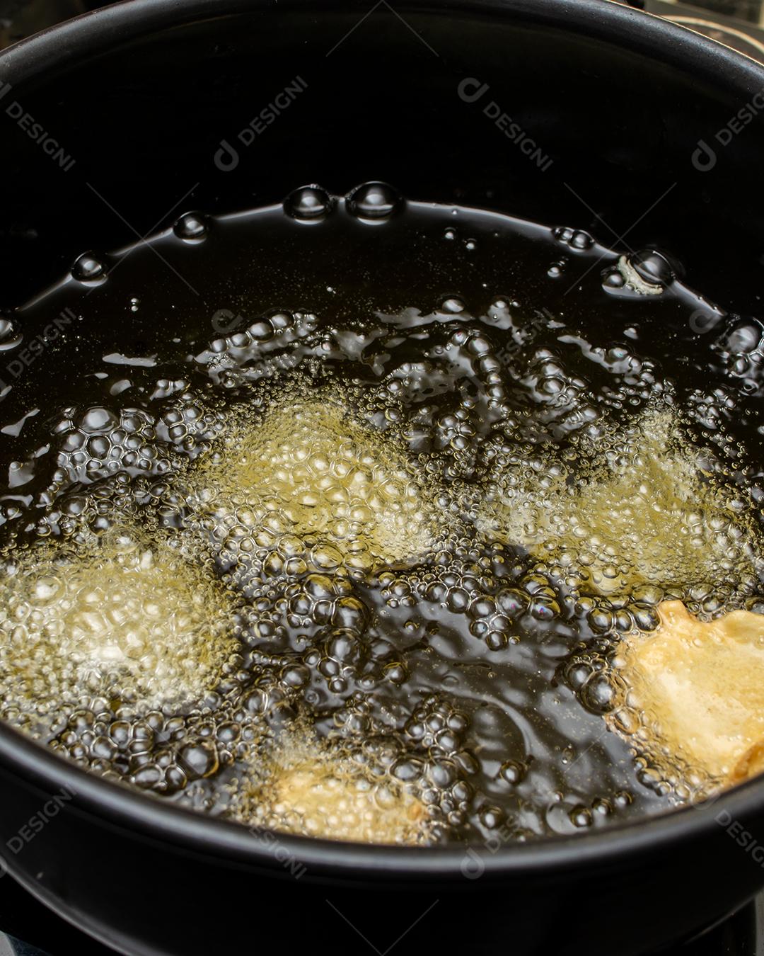 fritar a massa no óleo, para uma receita típica brasileira chamada bolinho de chuva