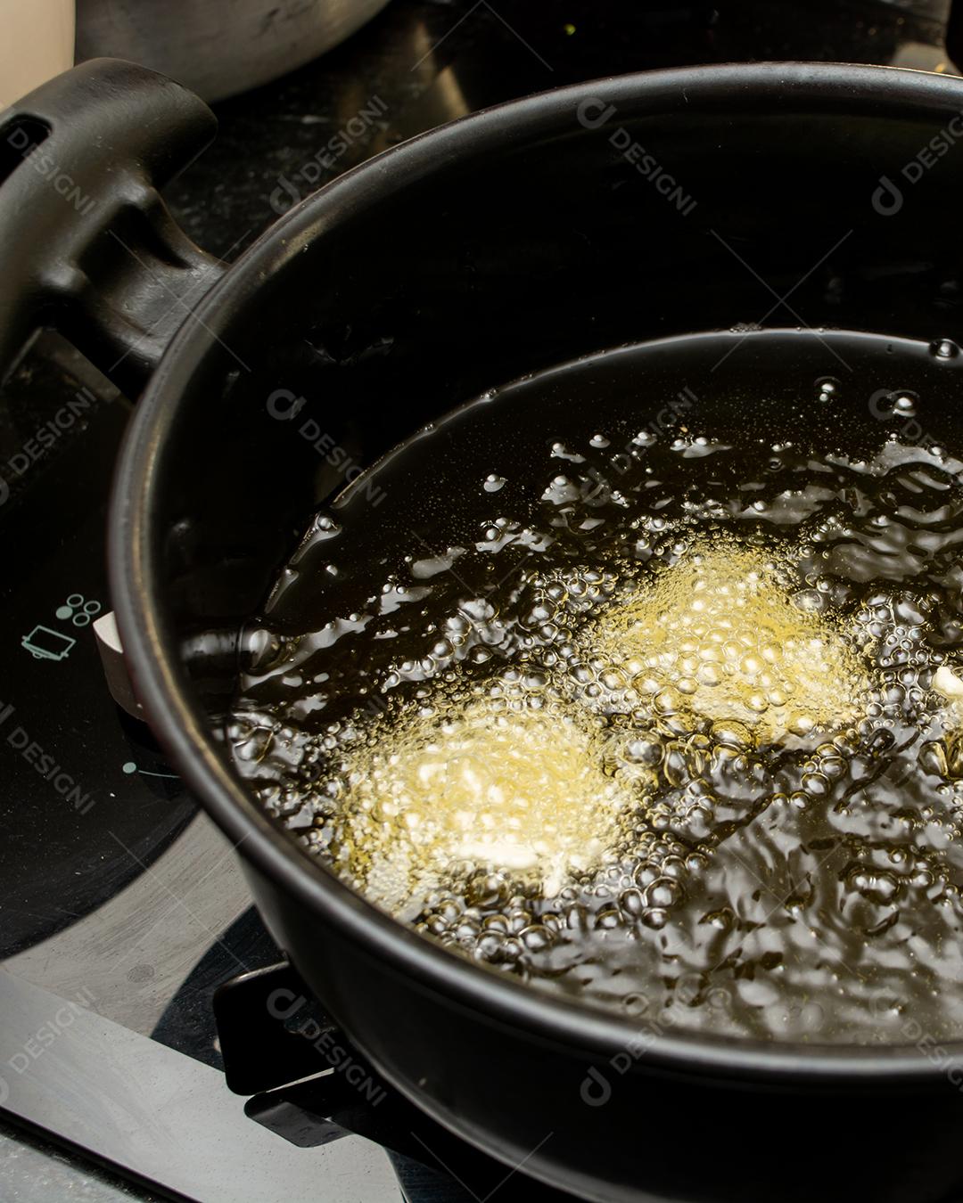 fritar a massa no óleo, para uma receita típica brasileira chamada bolinho de chuva