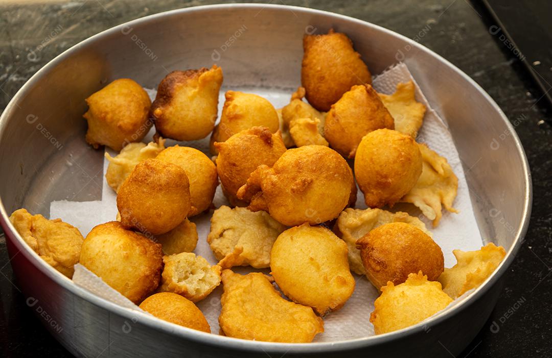 colocando açúcar e canela em uma massa frita conhecida como bolinho