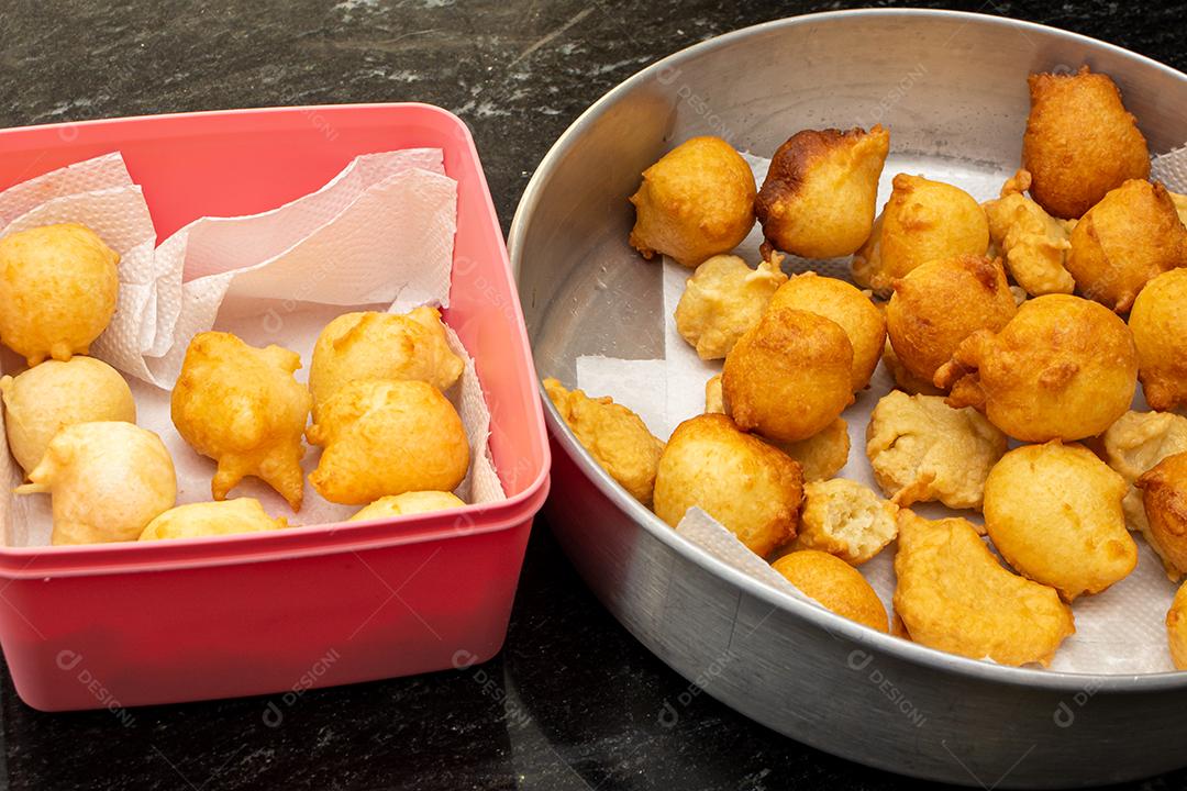 colocando açúcar e canela em uma massa frita conhecida como bolinho de chuva. uma receita típica e tradicional brasileira