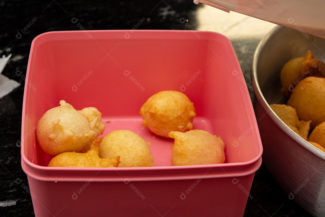 colocando açúcar e canela em uma massa frita conhecida como bolinho de chuva. uma receita típica e tradicional brasileira