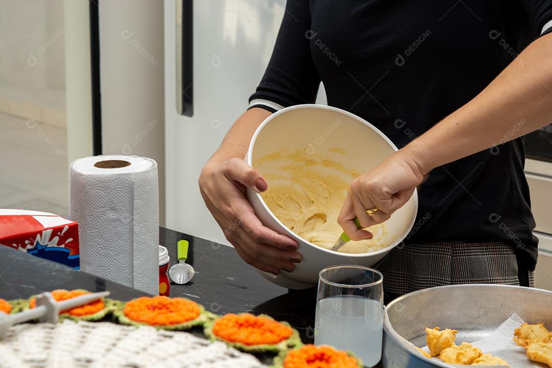 mulher preparando massa para fritar na cozinha em uma tigela de batedeira