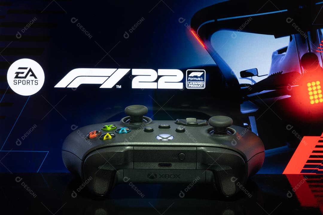 Controlador Xbox Series com logotipo F1 22 na tela da TV, foco seletivo.