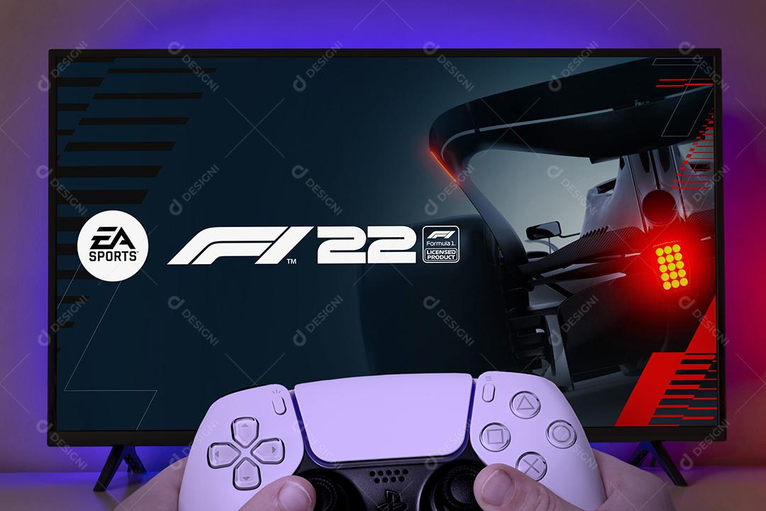 Garoto segurando o controle do Playstation 5 e jogando F1 22 na TV