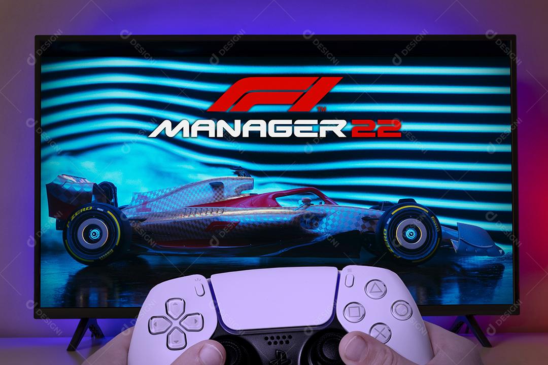 Garoto segurando o controle do Playstation 5 e jogando F1 Manager 22 na TV