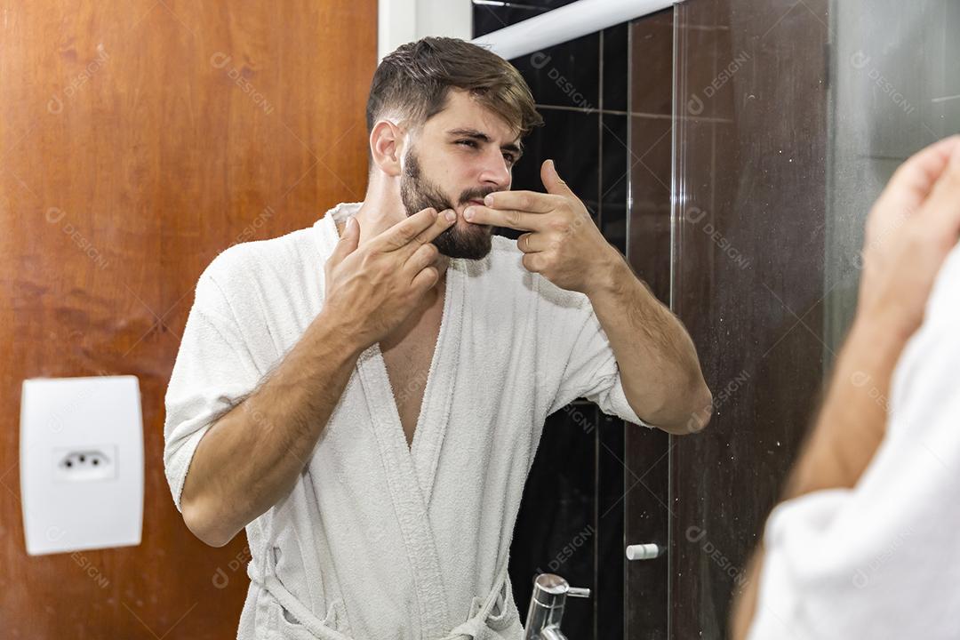 Rapaz bonito espremendo espinhas do rosto