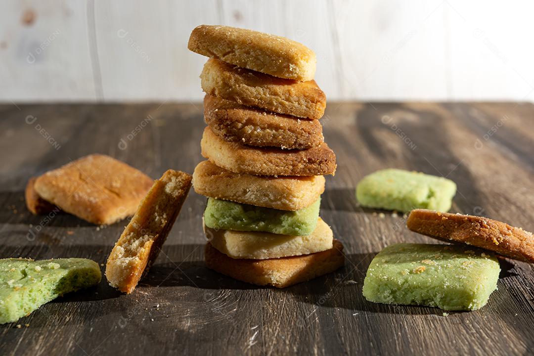 Bolinhos de polvilho empilhado sobre mesa madeira.