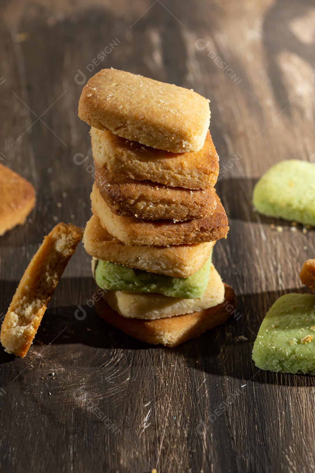 Bolinhos de polvilho empilhado sobre mesa madeira.