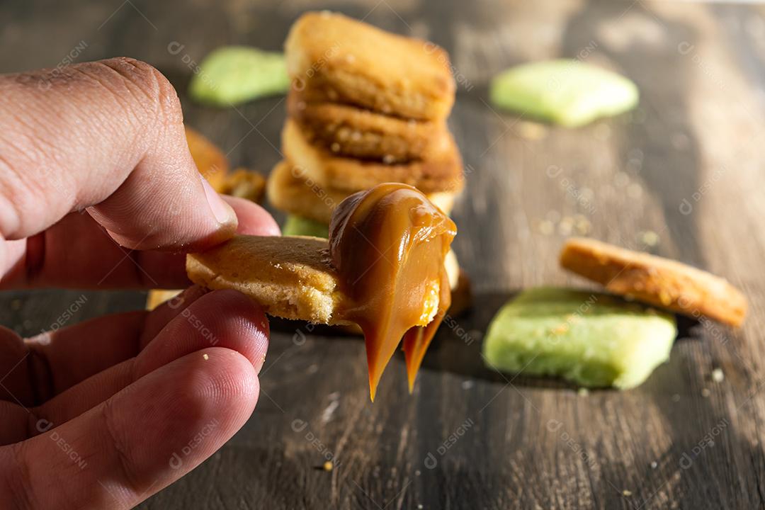 Bolinhos de polvilho empilhado sobre mesa madeira.