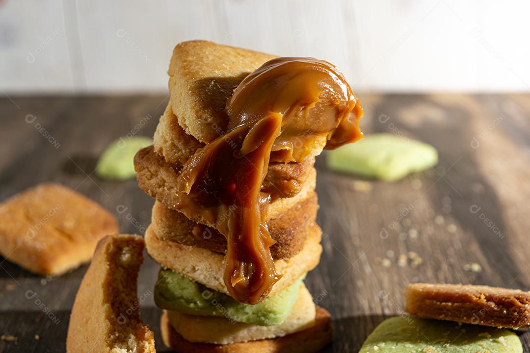 Bolinhos de polvilho empilhado sobre mesa madeira.