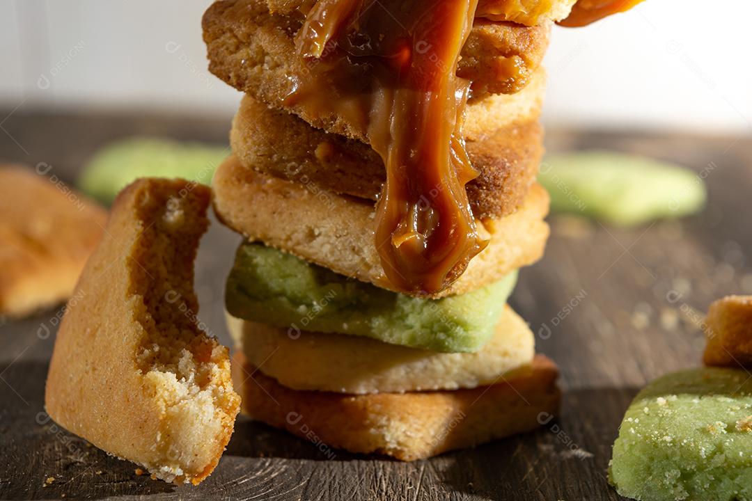 Bolinhos de polvilho empilhado sobre mesa madeira.