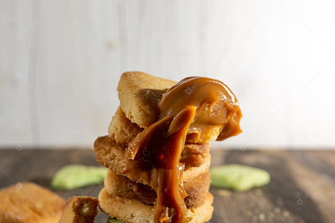 Bolinhos de polvilho empilhado sobre mesa madeira.