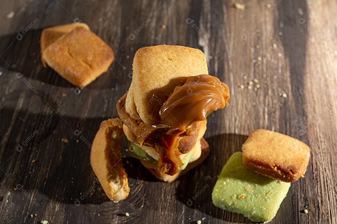 Bolinhos de polvilho empilhado sobre mesa madeira.