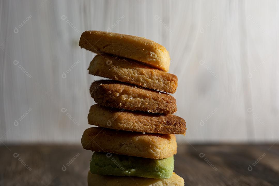 Bolinhos de polvilho empilhado sobre mesa madeira.